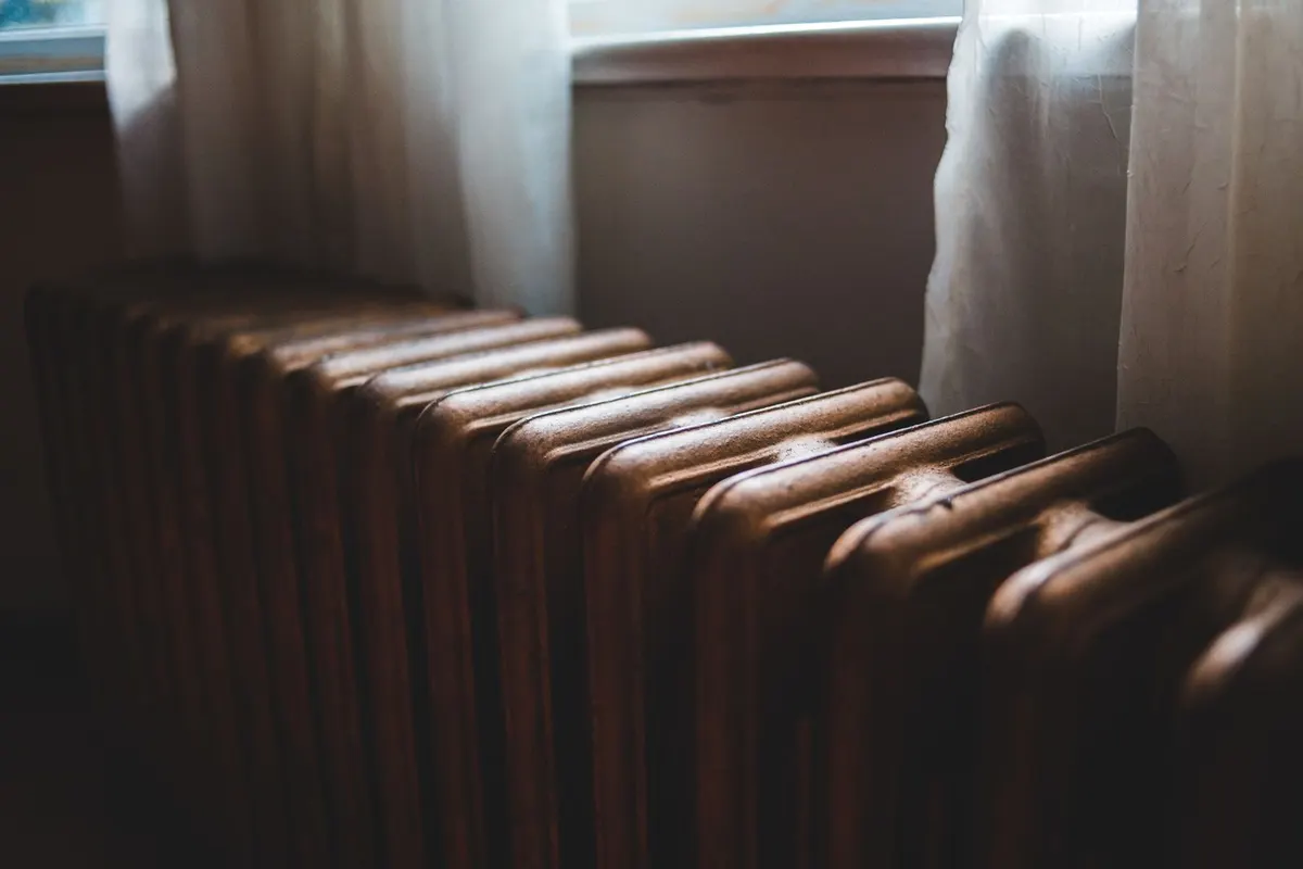 Cast-iron heating radiator below a window