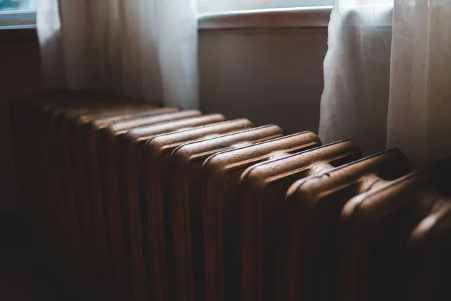 Cast-iron heating radiator below a window