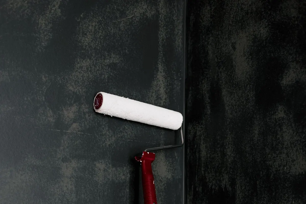 Paint roller applying a coat to an interior wall