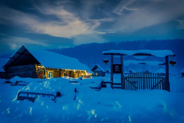 A warmly lit home surrounded by winter snow